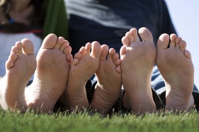 three person sleeping on grass showing there legs