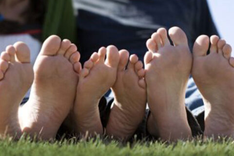 three person sleeping on grass showing there legs